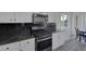 Well-lit kitchen boasting granite countertops, stainless steel appliances, and light wood floors at 2528 Huber Heights Dr, Las Vegas, NV 89128