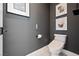 Cozy powder room featuring contemporary artwork, toilet, and stylish gray wall color at 2722 Marchetti Pl, Henderson, NV 89044