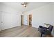 Bright bedroom features wood floors, a ceiling fan, an accent chair, and access to the bathroom at 2722 Marchetti Pl, Henderson, NV 89044