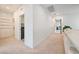 Bright hallway with minimalist white walls, neutral carpet, and access to laundry room and bedrooms at 2722 Marchetti Pl, Henderson, NV 89044