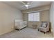 Bedroom with a crib, cozy chair, and soft carpet at 278 Star Cluster Cir, Las Vegas, NV 89145