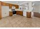 Eat-in kitchen featuring tile floors, white appliances, and wood cabinets at 3053 Monroe Park Rd, Henderson, NV 89052