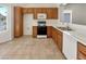 Well-lit kitchen with wood cabinets, white countertops, tile flooring, and appliances at 3053 Monroe Park Rd, Henderson, NV 89052