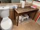 Small half bathroom featuring toilet and rustic vanity with open storage underneath at 3447 One Nation Ave, Las Vegas, NV 89121