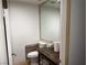 Small half bathroom featuring a toilet and dark colored vanity with a framed mirror at 3447 One Nation Ave, Las Vegas, NV 89121