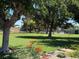 Lush community green space with mature trees, colorful flowers, and a view of the neighborhood pool at 3447 One Nation Ave, Las Vegas, NV 89121