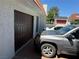 View of a two-car garage with brown door, white stucco, and vehicles parked in the driveway at 3447 One Nation Ave, Las Vegas, NV 89121