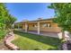Lush backyard featuring a covered patio, green lawn, mature trees, and block wall fence at 3557 Wayne Cir, Las Vegas, NV 89121