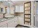 Bathroom features a sink, vanity, modern mirror, and storage shelves with decor baskets at 3557 Wayne Cir, Las Vegas, NV 89121