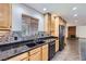 A stylish kitchen boasts granite countertops, mosaic backsplash, and stainless-steel appliances at 3557 Wayne Cir, Las Vegas, NV 89121