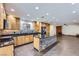 Open-concept kitchen and living area with an island, wood cabinets, black appliances, and brick fireplace at 3557 Wayne Cir, Las Vegas, NV 89121
