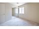 Empty bedroom featuring an mirrored sliding door closet and a large window for ample natural light at 3640 Shanagolden St, Las Vegas, NV 89129
