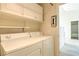 Convenient laundry area includes washer, dryer, and storage cabinets above, next to bathroom at 3640 Shanagolden St, Las Vegas, NV 89129