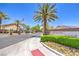 Welcoming street view of the Cheyenne Ridge community entrance with palm trees and an American flag at 3640 Shanagolden St, Las Vegas, NV 89129
