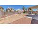 Spacious backyard featuring gravel landscaping and a covered patio, enclosed by a brick wall at 4420 Loma Ct, Las Vegas, NV 89130