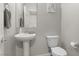 Cozy half bath featuring a pedestal sink, toilet, and decorative mirror at 4498 Lantern Point Ave, North Las Vegas, NV 89084