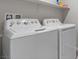 A laundry room showcasing a modern washer and dryer, plus shelf at 4498 Lantern Point Ave, North Las Vegas, NV 89084