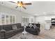 Open concept living room featuring gray sofas, ceiling fan, and tile floors at 4498 Lantern Point Ave, North Las Vegas, NV 89084