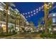 Apartments with decorative outdoor lighting, palm trees and landscaping along with shops in the foreground at 511 Beaconwood St, Henderson, NV 89052