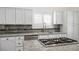 Close-up of a modern kitchen featuring white cabinets, granite countertops, and stainless steel appliances at 511 Beaconwood St, Henderson, NV 89052