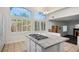 Spacious kitchen with large windows, granite island, white cabinetry and tiled floor at 511 Beaconwood St, Henderson, NV 89052