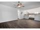 Open-concept living room with wood floors, ceiling fan, and seamless transition to kitchen at 511 Beaconwood St, Henderson, NV 89052