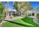 Green backyard with patio, artificial turf, and desert landscaping at 5224 Painted Lakes Way, Las Vegas, NV 89149
