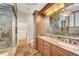 Updated bathroom features dual sinks, marble counters, and a glass enclosed shower and tub at 5224 Painted Lakes Way, Las Vegas, NV 89149
