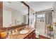 Granite vanity in bathroom with large mirror and tile shower/tub at 5224 Painted Lakes Way, Las Vegas, NV 89149