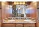 Luxury bathroom showcasing dual sinks, granite countertop, and wooden cabinets at 5224 Painted Lakes Way, Las Vegas, NV 89149