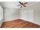 Well-lit bedroom with ceiling fan, hardwood floors, base trim, and closet with sliding doors at 5224 Painted Lakes Way, Las Vegas, NV 89149