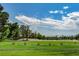Picturesque view of the golf course's green landscape, sand traps, and clear blue skies with clouds at 5224 Painted Lakes Way, Las Vegas, NV 89149
