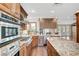 Gourmet kitchen with granite counters, stainless appliances, and wood cabinetry at 5224 Painted Lakes Way, Las Vegas, NV 89149
