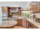 Close up of a kitchen with wood cabinets, granite countertops, and stainless steel appliances at 5224 Painted Lakes Way, Las Vegas, NV 89149