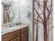 Neutral bathroom with a single sink, brown cabinets, and a decorative tree-themed shower curtain at 5301 River Glen Dr # 205, Las Vegas, NV 89103