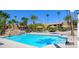 A sparkling swimming pool features clear blue water, palm trees, and shaded seating areas, offering a resort-like experience at 5301 River Glen Dr # 205, Las Vegas, NV 89103