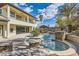 Beautiful backyard featuring a pool, spa, covered outdoor kitchen, lush landscaping and mountain views at 5367 Secluded Brook Ct, Las Vegas, NV 89149