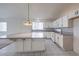 Bright kitchen with white cabinets, tile backsplash, large island, and tile flooring at 5425 Thomaston Ct, Las Vegas, NV 89122