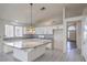 Well-lit kitchen with a central island, white cabinets, and tile flooring leading to the entryway at 5425 Thomaston Ct, Las Vegas, NV 89122