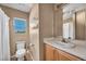 Well-lit bathroom featuring a toilet, vanity, mirror, and a window for natural light at 582 Brompton St, Las Vegas, NV 89178