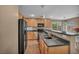 Bright kitchen featuring wood cabinets, a black refrigerator and a cozy eat-in area by the window at 582 Brompton St, Las Vegas, NV 89178
