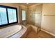 Bathroom featuring jacuzzi bathtub, step-in shower, and tile flooring at 585 Via Alhambra, Las Vegas, NV 89123