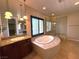 Bathroom featuring jacuzzi bathtub, step-in shower, dark wood cabinets and granite countertop at 585 Via Alhambra, Las Vegas, NV 89123