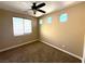 Neutral bedroom featuring a ceiling fan, carpet flooring, and natural light from three windows at 585 Via Alhambra, Las Vegas, NV 89123