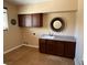 Laundry room featuring tile floors, dark wood cabinets, and countertop space at 585 Via Alhambra, Las Vegas, NV 89123