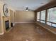 Spacious living room features tile flooring, a ceiling fan, a fireplace and multiple windows at 585 Via Alhambra, Las Vegas, NV 89123
