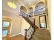 Elegant staircase with dark wood railings and arched entryways on upper level at 585 Via Alhambra, Las Vegas, NV 89123