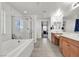 Bathroom featuring dual sinks, tub, walk-in shower and tile floors at 6370 Ava Ridge Ave, Las Vegas, NV 89141