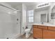This bathroom has a glass door shower, and wood colored cabinets at 6370 Ava Ridge Ave, Las Vegas, NV 89141