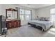 Bright bedroom featuring dresser, mirror, bed with storage, and two windows at 6370 Ava Ridge Ave, Las Vegas, NV 89141
